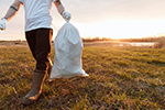 person walking with trash bag